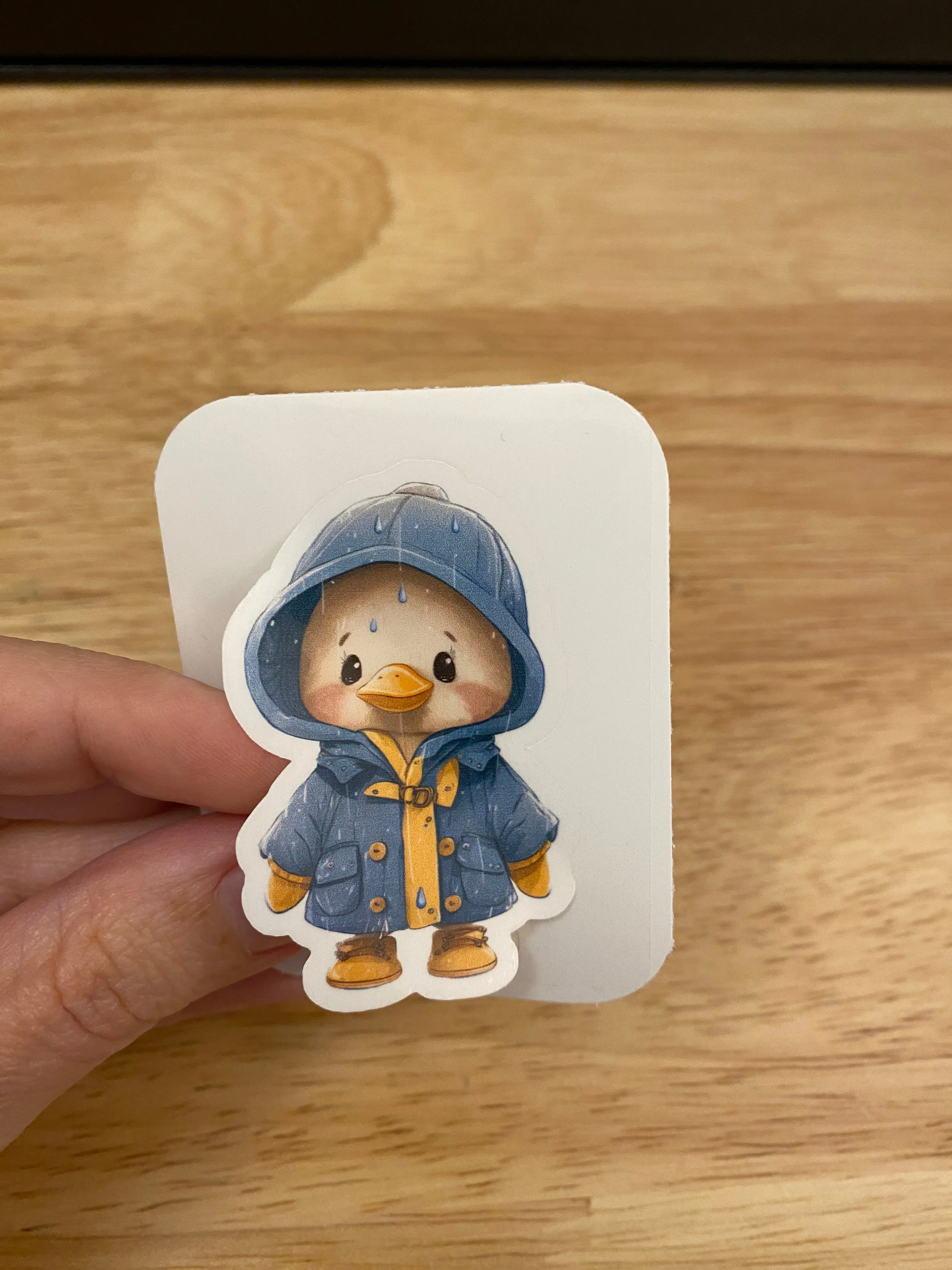 Yellow duck in blue rain jacket sticker